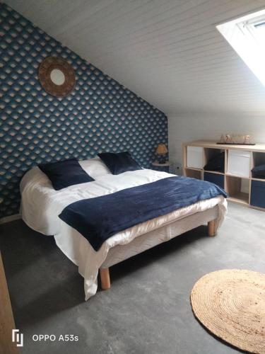 a bedroom with a bed with a blue wall at Appartement centre lannion in Lannion