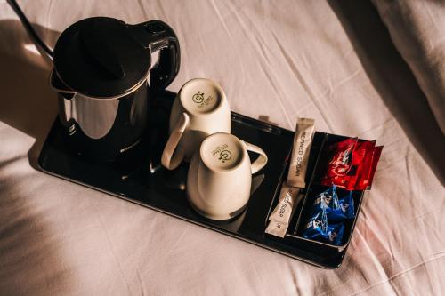 巴德里纳特New Hotel Snow Crest的床上的茶壶和杯子托盘