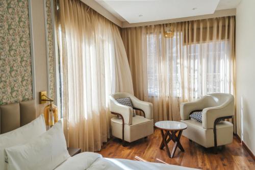 a hotel room with two chairs and a bed and a window at New Hotel Snow Crest in Badrīnāth