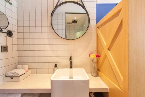 a bathroom with a sink and a mirror at Happy Inn-Zhengzhou Railway St ation Erqi Square Branch喜鹊愉家酒店锦荣国际轻纺城店 in Zhengzhou