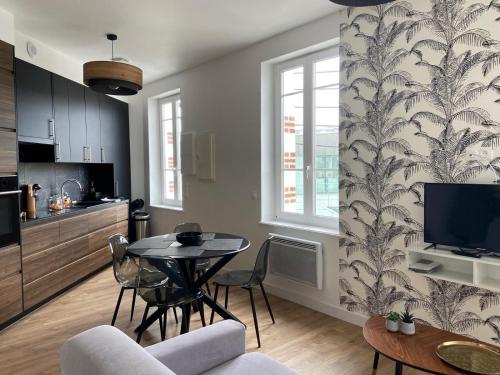 une cuisine et un salon avec une table et des chaises dans l'établissement Les trois plages, à Dinard