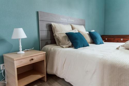 a bedroom with a large white bed with blue walls at le refuge des cépages - essoyes in Essoyes
