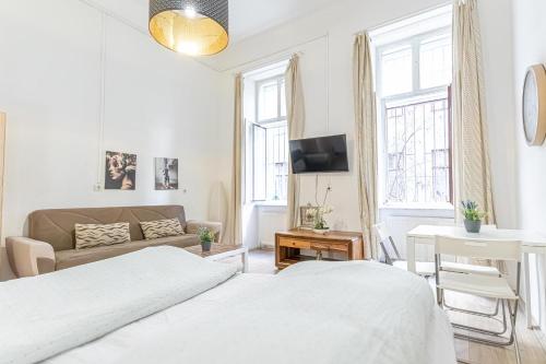 biała sypialnia z 2 łóżkami i kanapą w obiekcie Chic Apartment- Suitable for Longstays near Matzleinsforferplatz w Wiedniu