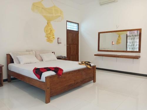a bedroom with a bed and a mirror on the wall at Yala Eco Shine in Tissamaharama
