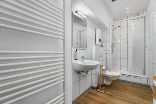 ein weißes Badezimmer mit Waschbecken und Toilette in der Unterkunft ROTH Apartments Solingen-HBF in Solingen
