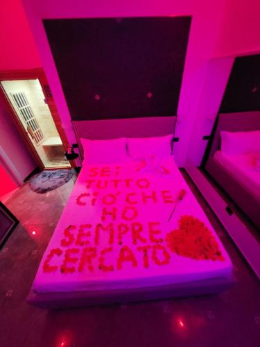 a pink room with a bed with a pink light at B&B GRECALE Suite & Spa in Rende