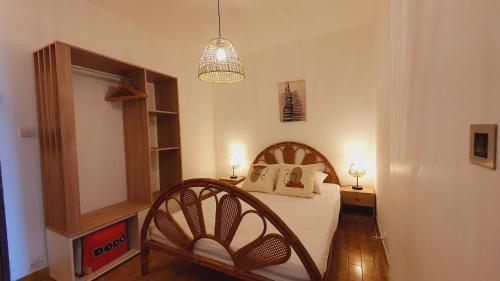 une chambre avec un lit et un lustre dans l'établissement Agréable T2 Parking Clim Lac & Golf 4 personnes - ROSSIconciergerie - Linge en option, à La Grande Motte