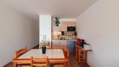 une cuisine avec une table en bois et une table et des chaises dans l'établissement Agréable T2 Parking Clim Lac & Golf 4 personnes - ROSSIconciergerie - Linge en option, à La Grande Motte