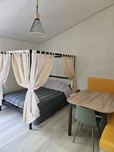 Ce lit se trouve dans un dortoir doté d'une table et d'une table. dans l'établissement Joli Cottage Tiny en forêt au Village Vacances, à Mareuil-sur-Lay