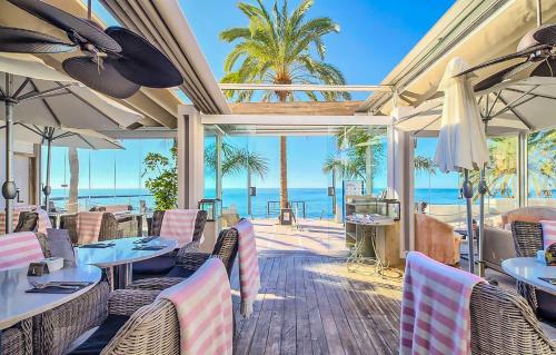 a restaurant with tables and chairs and a view of the ocean at Au petit bonheur parking gratuit in Cavalaire-sur-Mer