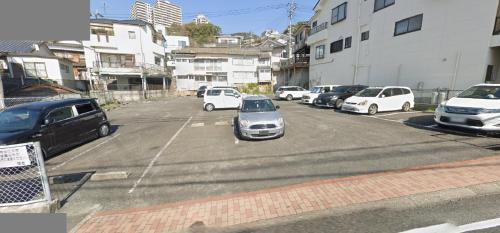 a parking lot with a bunch of cars parked in it at ステイインアット今福 in Sasebo