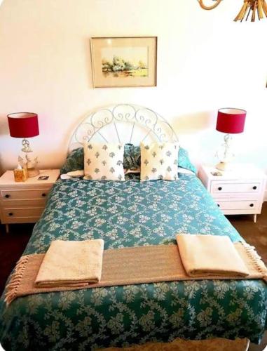 a bedroom with a green bed with two night stands at Regis Lodge Guest House in Bognor Regis