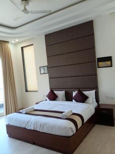 a bedroom with a large bed with a wooden headboard at Hotel Florence near Artemis Hospital in Gurgaon