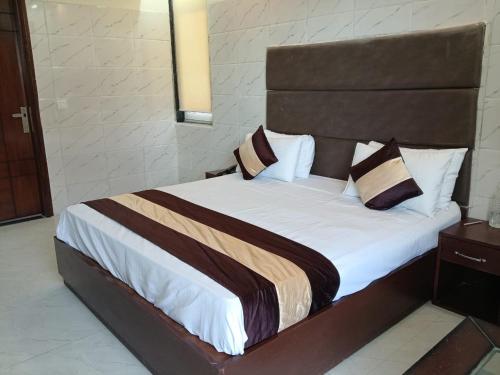 a bedroom with a large bed with a wooden headboard at Hotel Florence near Artemis Hospital in Gurgaon
