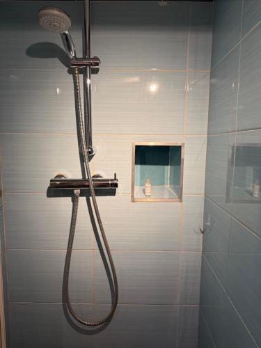 a shower with a shower head in a bathroom at James Joyce - Metro Cubo in Trieste