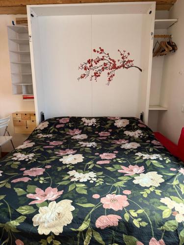 a bedroom with a bed with a floral bedspread at James Joyce - Metro Cubo in Trieste