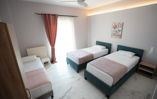 a hotel room with two beds and a window at Meteora House with a view in Kalabaka