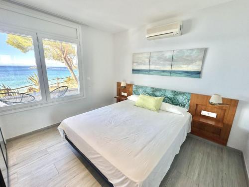 ein Schlafzimmer mit einem Bett mit Blick auf das Meer in der Unterkunft Almadrague Villa in Roses