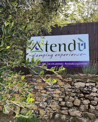 a sign for a herbal gardening experience behind a stone wall at Arya in Chiusanico