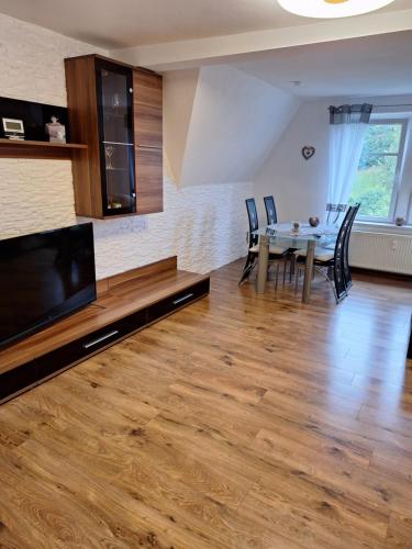 a living room with a dining room table and a television at Ferienwohnung Rote-Villa in Marienberg