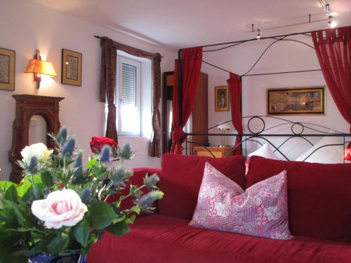 a living room with a red couch with a vase of flowers at Chalet Valley in Valley