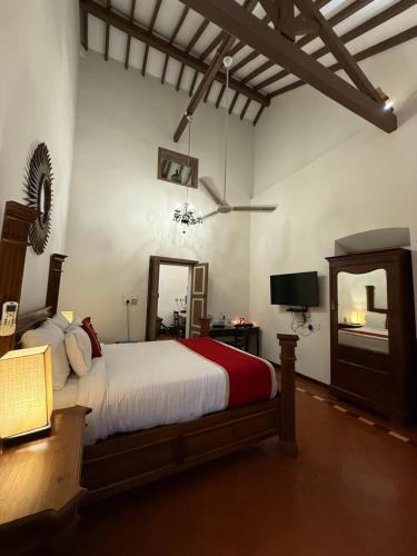 a bedroom with a large bed and a mirror at Lar Amorosa Boutique Hotel - Goa in Calangute