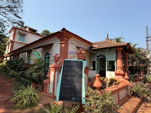 a small house with a chalkboard sign in front of it at Lar Amorosa Boutique Hotel - Goa in Calangute