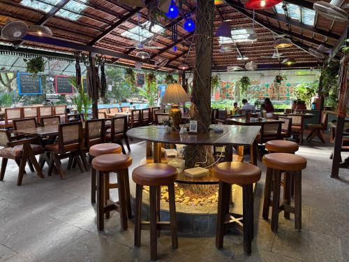 a restaurant with tables and chairs and a tree at Lar Amorosa Boutique Hotel - Goa in Calangute