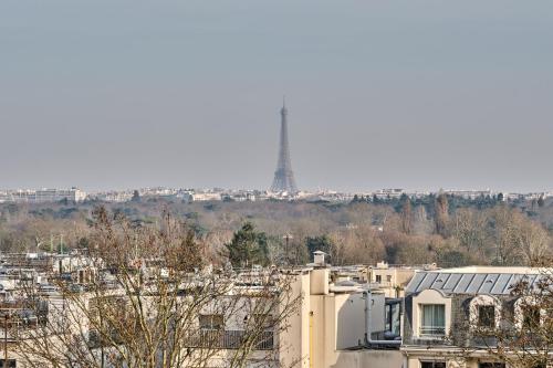 a view of a city with a tower in the background at Hotel Atrium by Happyculture in Suresnes