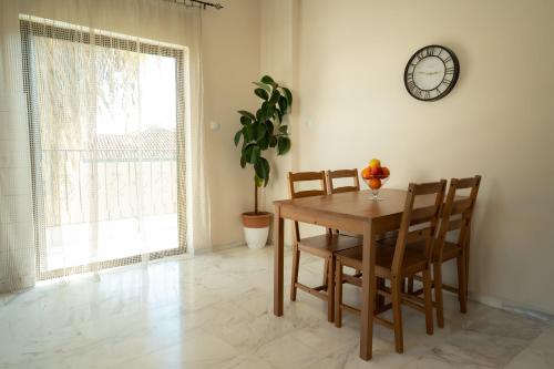 a dining room table with two chairs and a clock on the wall at Meteora House with a view in Kalabaka