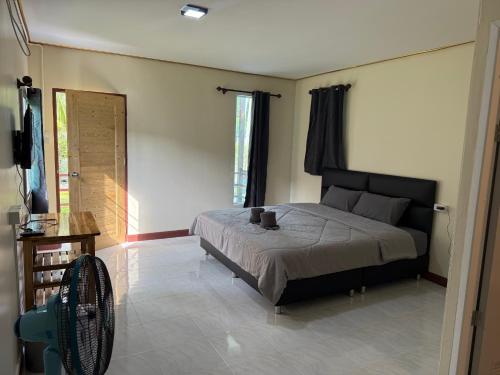 Ban Bang BaoNgopaKohKoodResort的一间卧室配有一张床和一个风扇