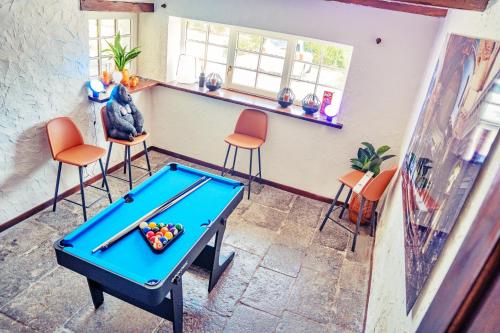 a ping pong table in a room with chairs at Gîte du Volcan in Namur