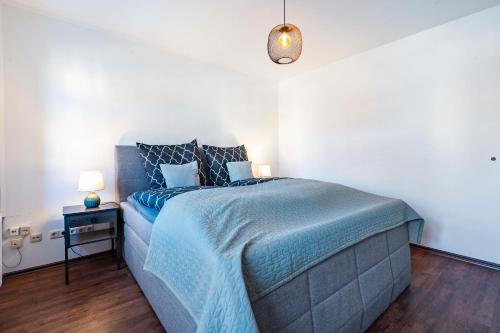 a bedroom with a bed with a blue comforter at Elbloft Radebeul Am Elberadweg Mit in Radebeul