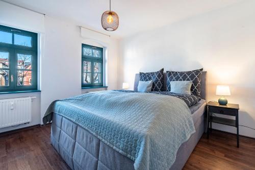 a bedroom with a large bed and two windows at Elbloft Radebeul Am Elberadweg Mit in Radebeul