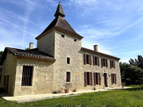 an old stone building with a tower on top at Maison au Domaine du Bilé - Climatisation parking in Solomiac