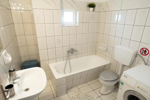 a white bathroom with a toilet and a sink at Meteora House with a view in Kalabaka