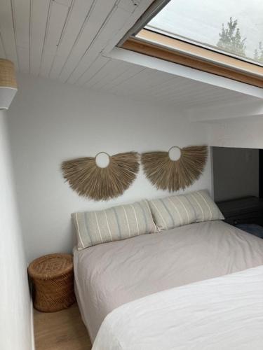 une chambre avec un lit blanc et une fenêtre dans l'établissement Charmante maison Charentaise, à Breuillet