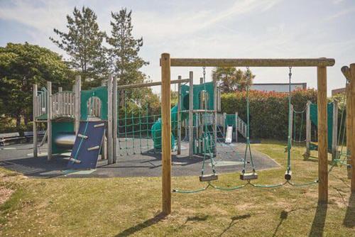 a playground in a park with a play equipment at Caravan Church farm holiday village in Pagham