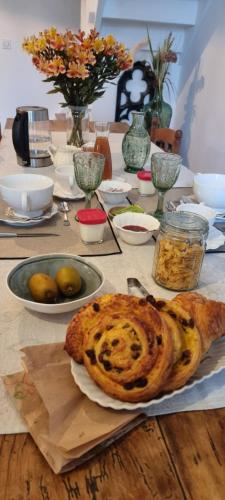 - une table avec du pain et une assiette de nourriture dans l'établissement Chambres d'Hôtes Ferme de la Baie, à Roz-sur-Couesnon