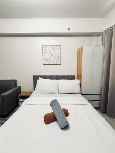 ein Schlafzimmer mit einem Bett und einem Handtuch darauf in der Unterkunft Snug Retreat with Cozy Vibes in Iloilo City