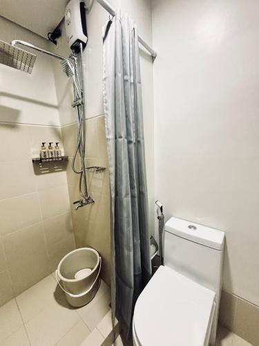 ein Bad mit einem Duschvorhang und einem WC in der Unterkunft Snug Retreat with Cozy Vibes in Iloilo City