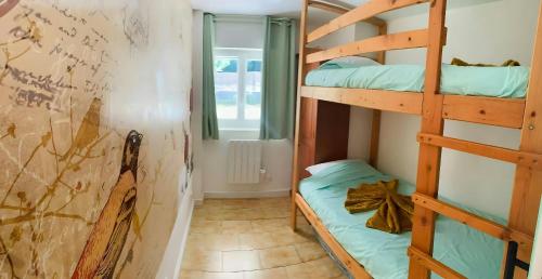 une chambre avec deux lits superposés et un mur dans l'établissement Le Coccoon'Ain, à Virignin