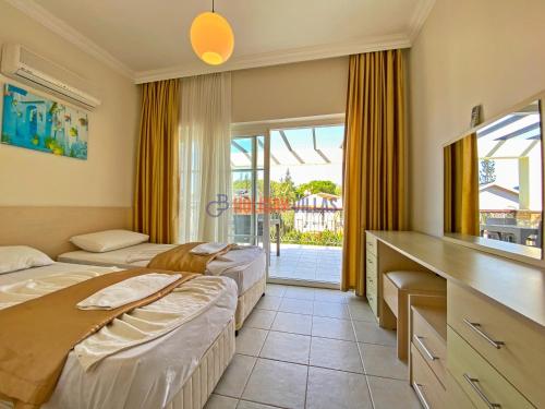 una camera d'albergo con due letti e un balcone di GOLD Villa 6 a Oludeniz