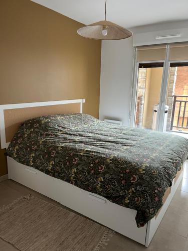 une chambre avec un lit avec une couette fleurie dans l'établissement Mont d'Auron - 3p- résidence neuve, à Auron