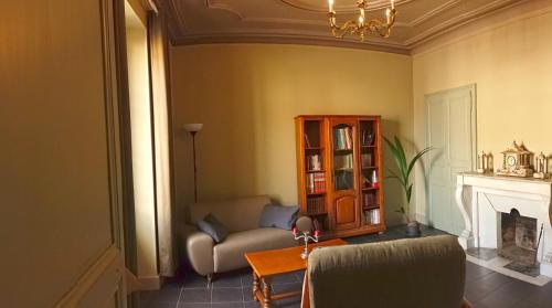 a living room with a chair and a fireplace at La Distillerie 1881 in Aillevillers-et-Lyaumont