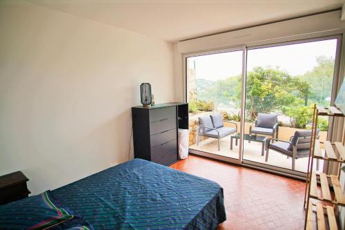 - une chambre avec un lit et une vue sur une terrasse dans l'établissement Au cœur du port de Saint-Mandrier, piscine, tennis, charme et confort, à Saint-Mandrier-sur-Mer