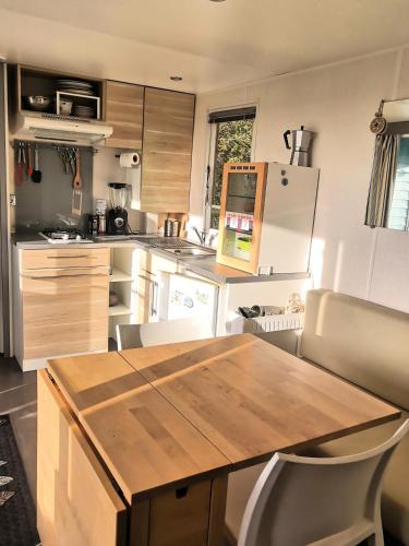 une cuisine avec une table en bois et un réfrigérateur dans l'établissement Refuge de Bonlieu, à Lieudieu