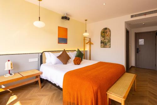 a bedroom with a large bed with an orange blanket at Wuzhen Xizha Slow Life Riverside Inn in Wujiaqiao