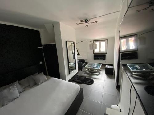 une chambre avec un lit blanc et un miroir dans l'établissement Suite Apollon, à Saint-Étienne
