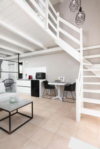 a living room with a loft with a spiral staircase at Eliathos Hillside Retreat in Archanes